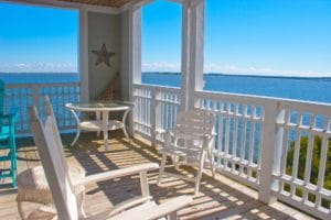 chairs sitting on balcony overlooking water